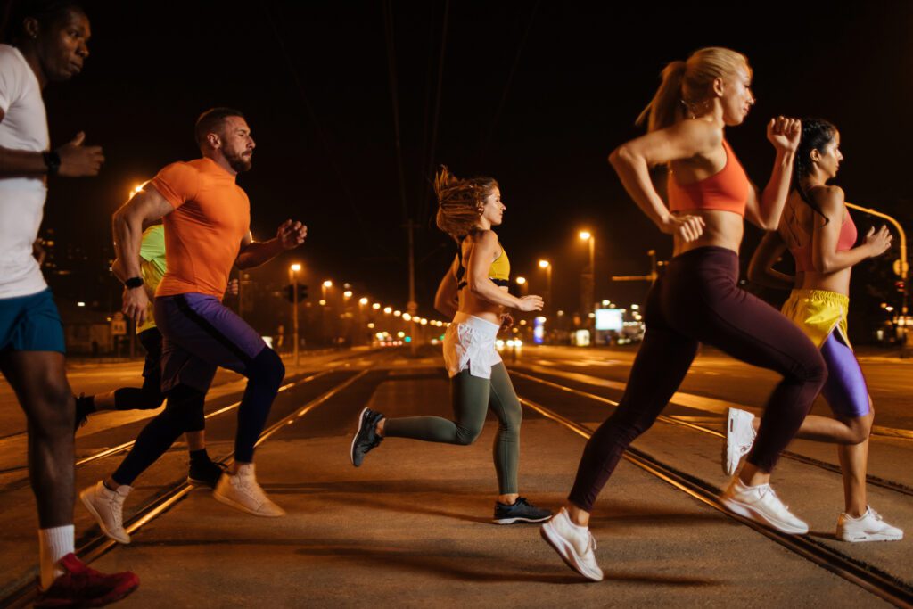 Μια ομάδα νεαρών αθλητικών ανθρώπων που γυμνάζονται τρέχοντας μαζί στην πόλη