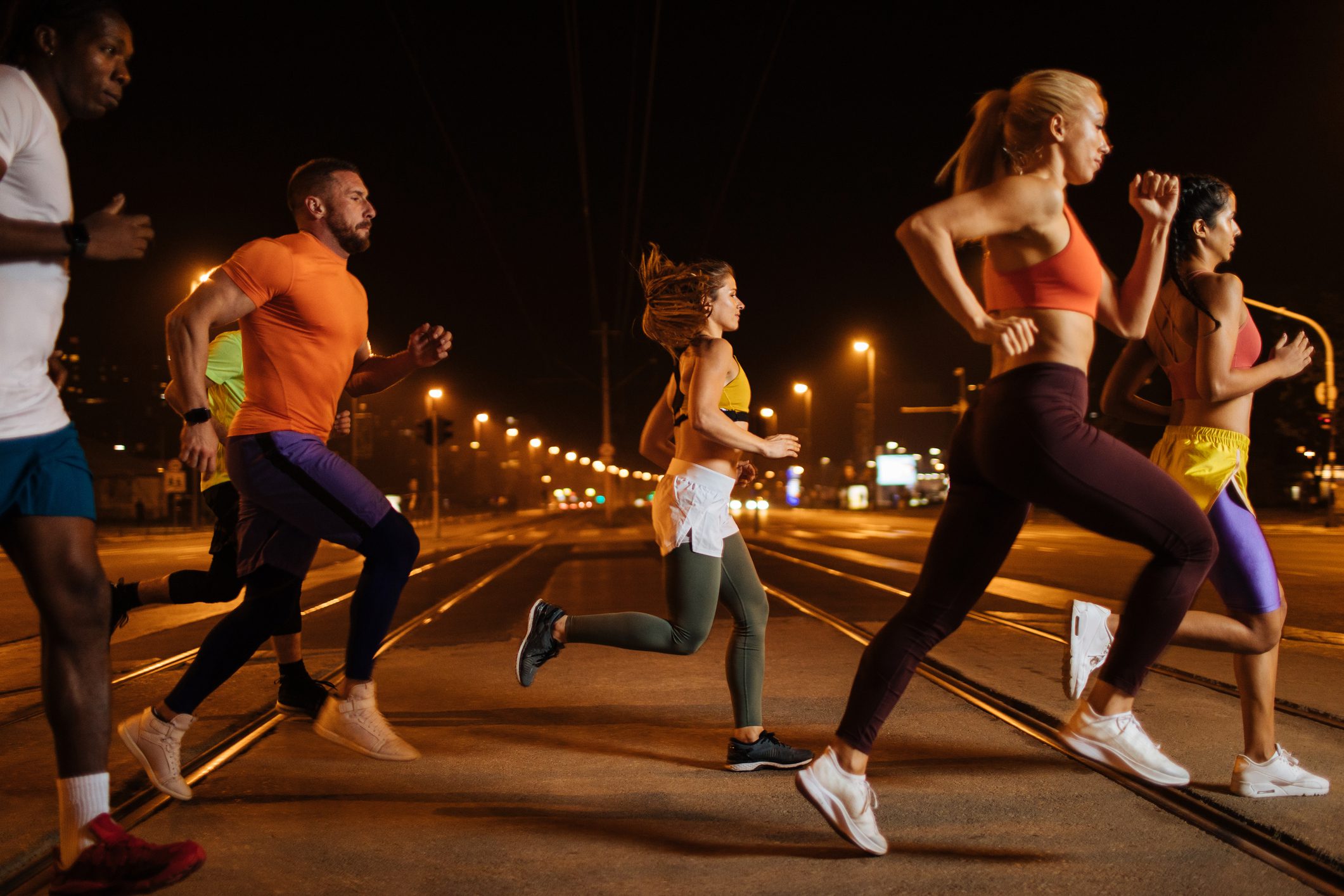 Μια ομάδα νεαρών αθλητικών ανθρώπων που γυμνάζονται τρέχοντας μαζί στην πόλη